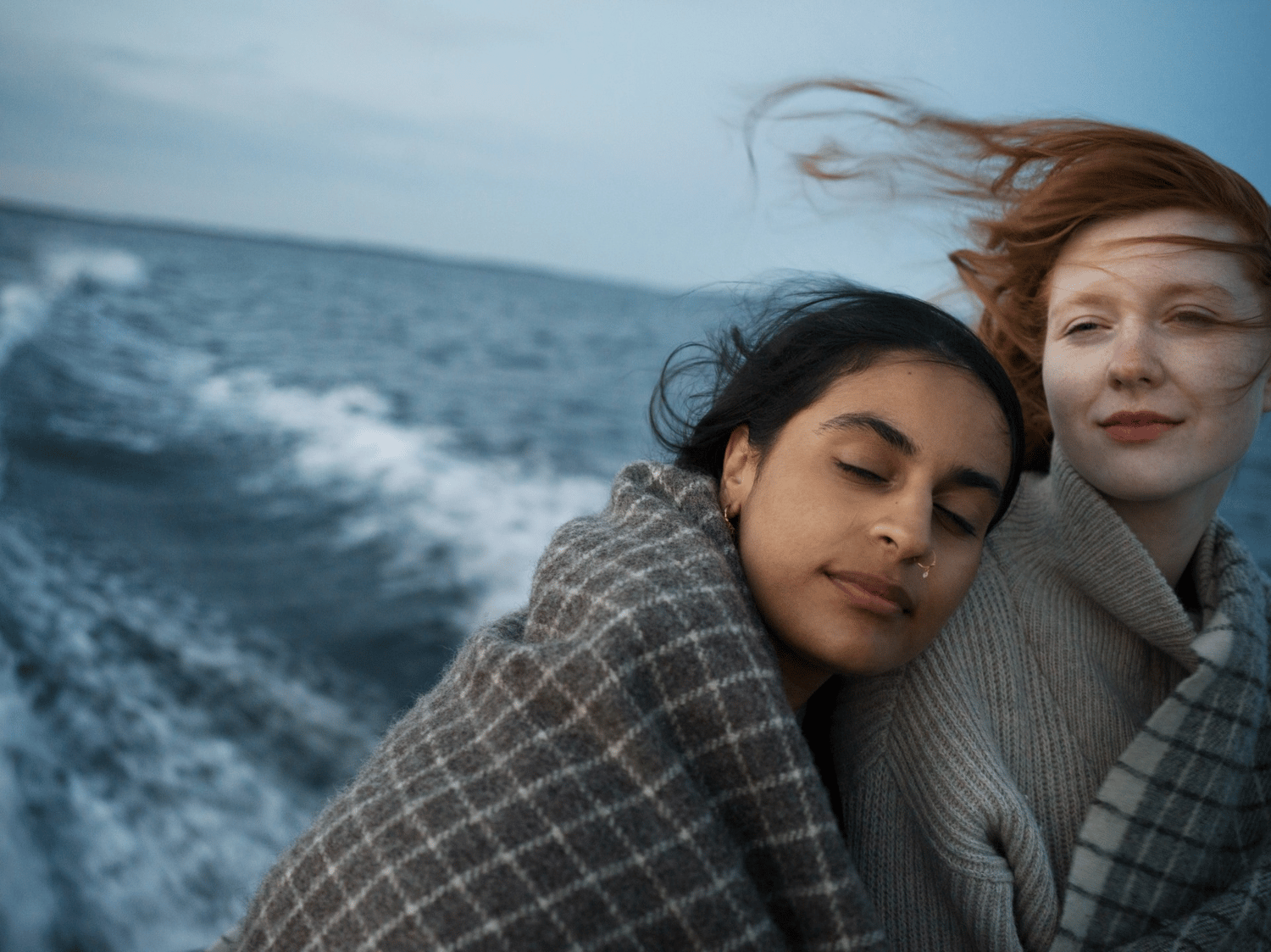 Two persons on the sea, leaning to each other 