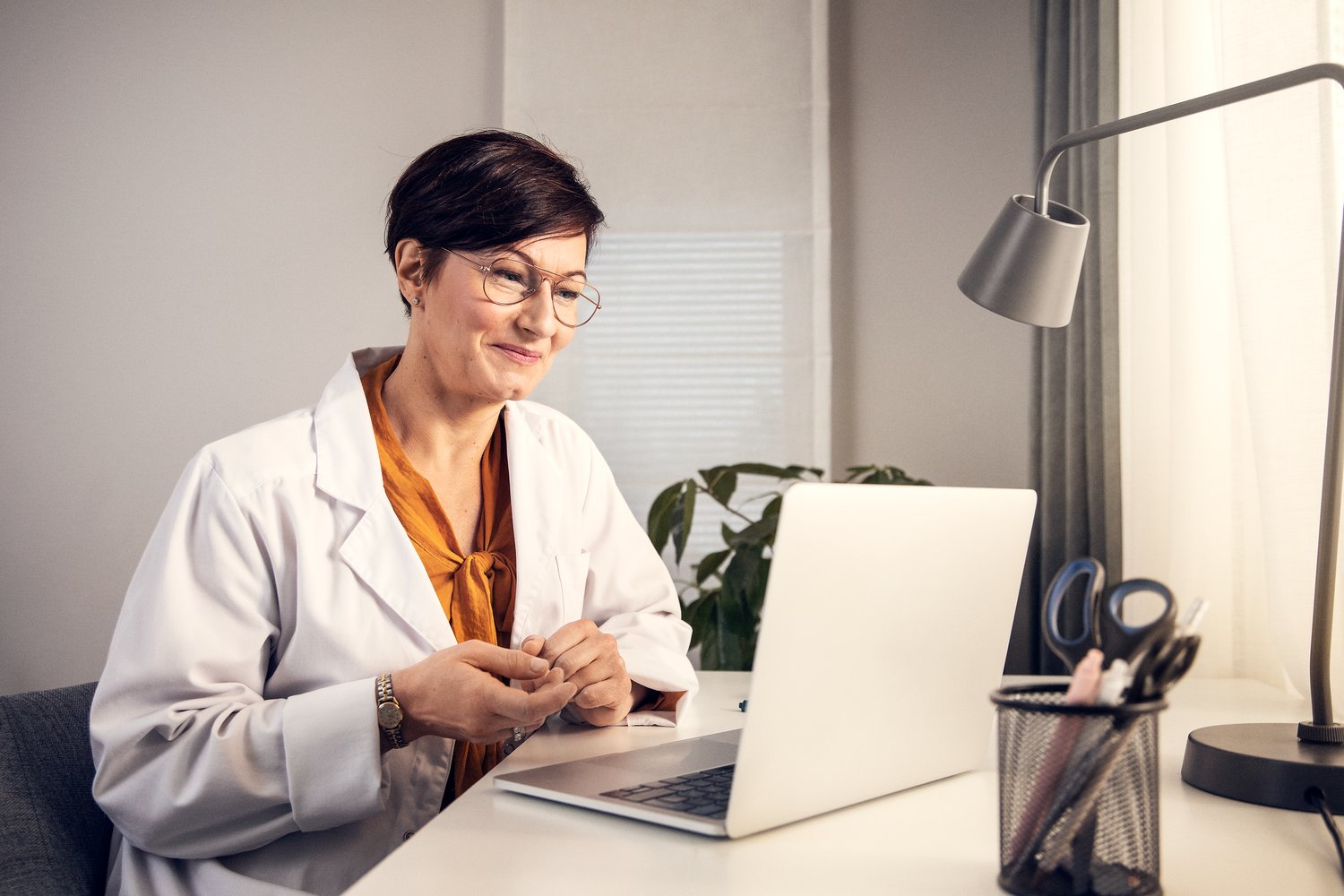 Healthcare practicioner look at laptop with Terveystalo platfom on it